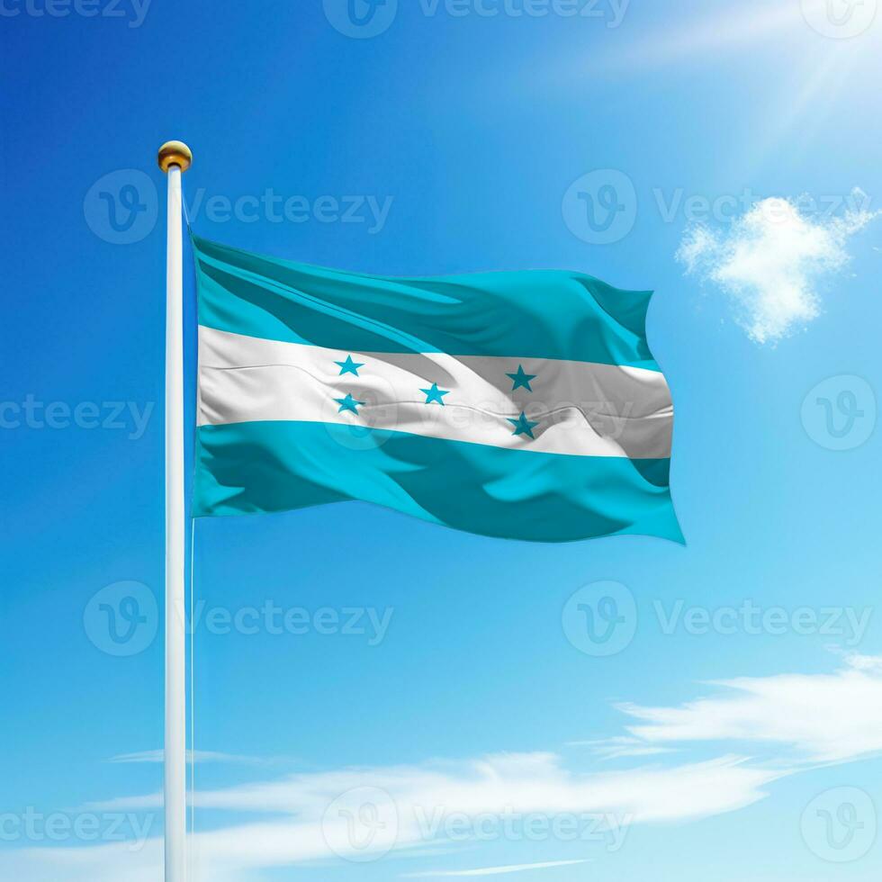 acenando bandeira do Honduras em mastro de bandeira com céu fundo. foto