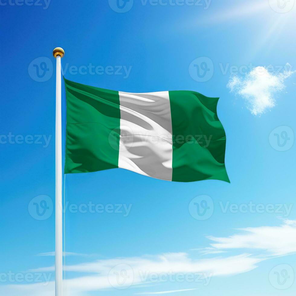 acenando bandeira do Nigéria em mastro de bandeira com céu fundo. foto