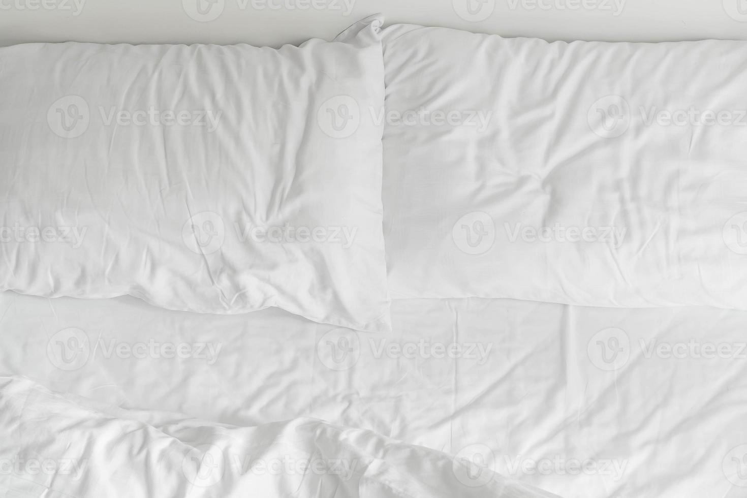 Cama com aro com decoração de travesseiro branco bagunçado no interior do quarto foto