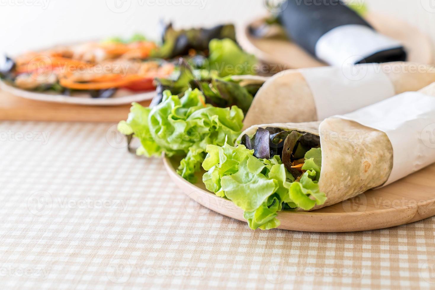 embrulhe o rolo de salada na mesa foto