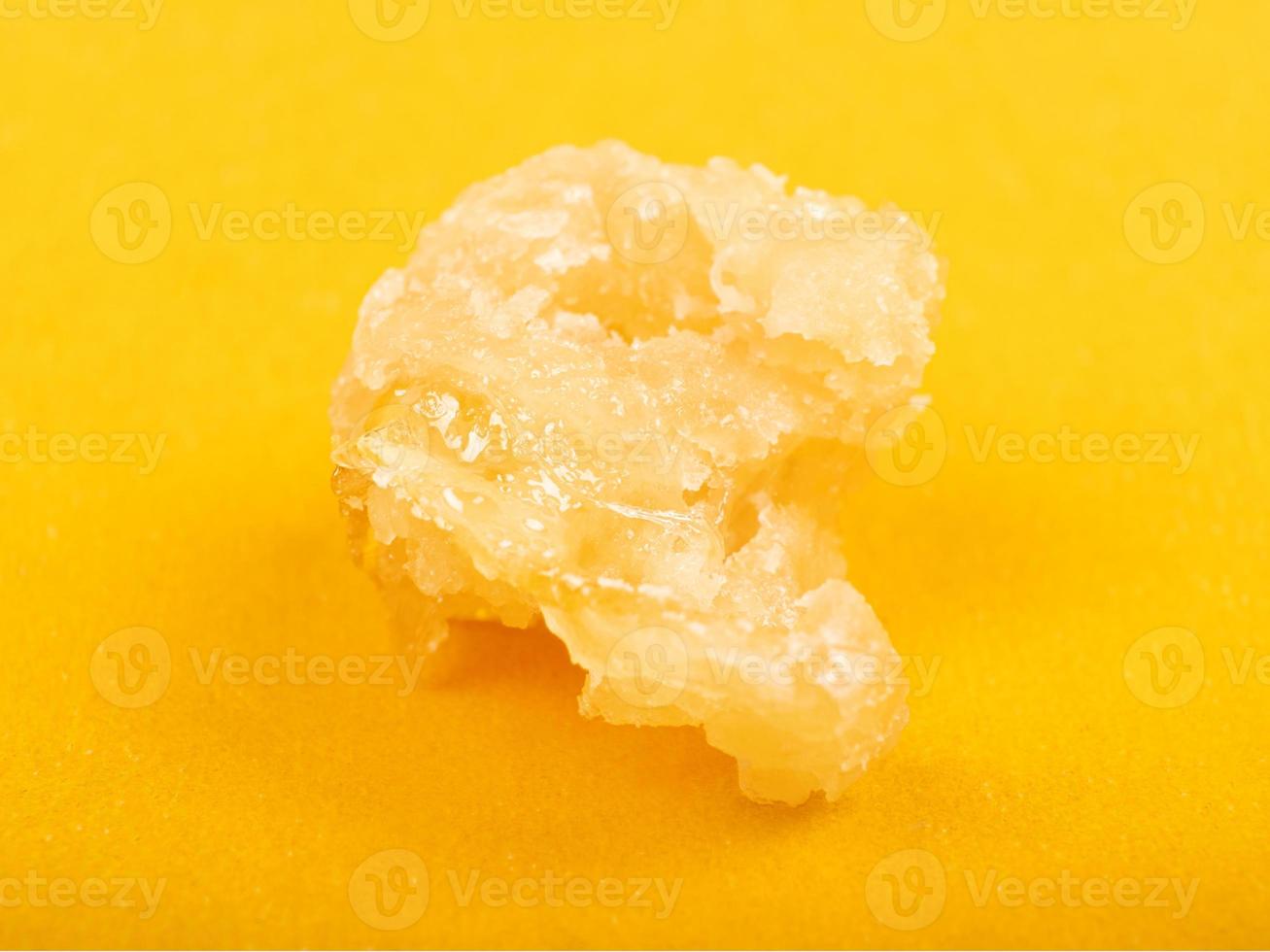 concentrado de cera de cannabis açúcar close-up em fundo amarelo foto