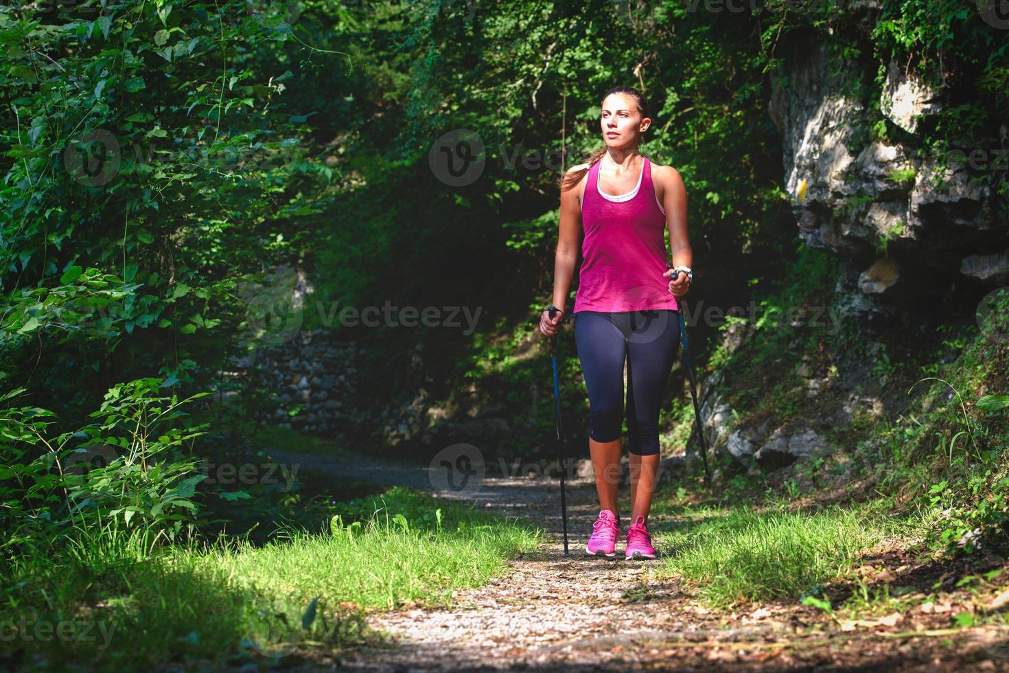 andar nórdico. uma jovem em uma caminhada na floresta foto