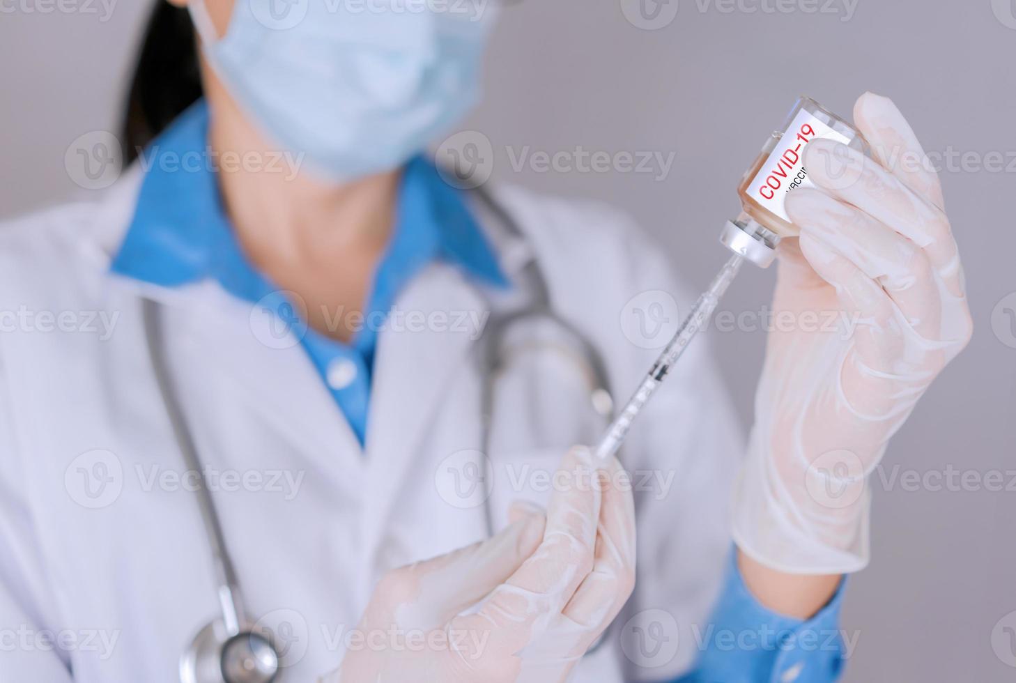médico enchendo seringa para tratar covid 19 e curar e proteger foto