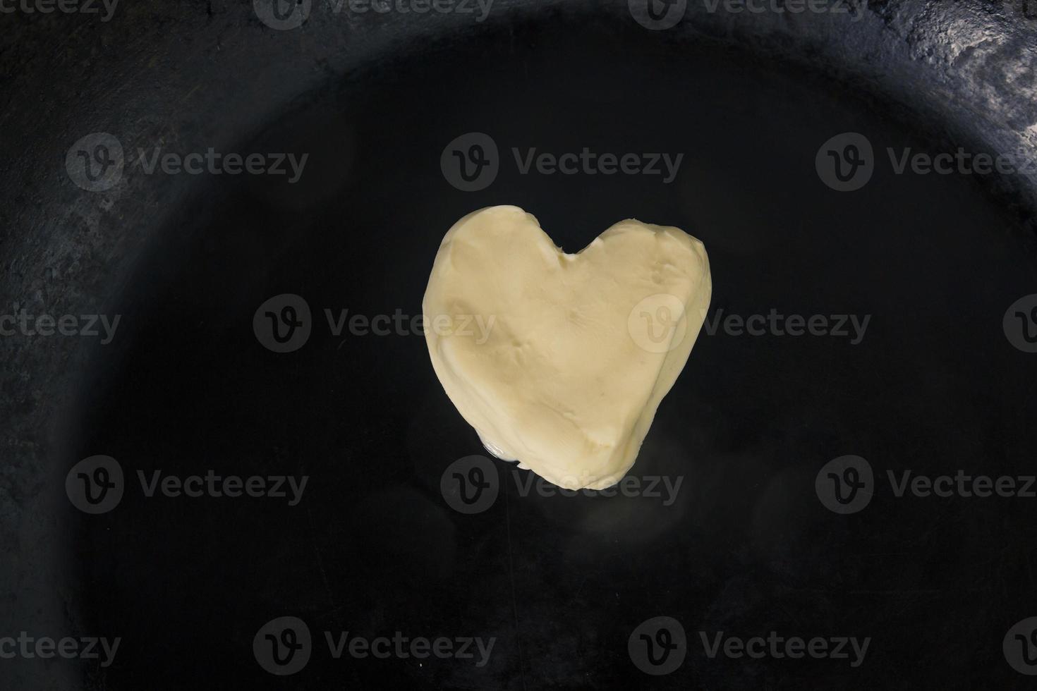 manteiga em forma de coração na panela quente - vista de cima de perto foto