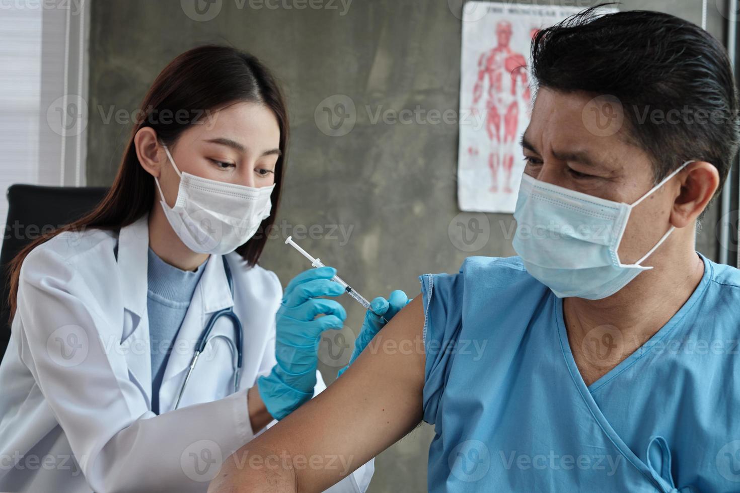 médico vacinando paciente asiático do sexo masculino para proteger covid19. foto