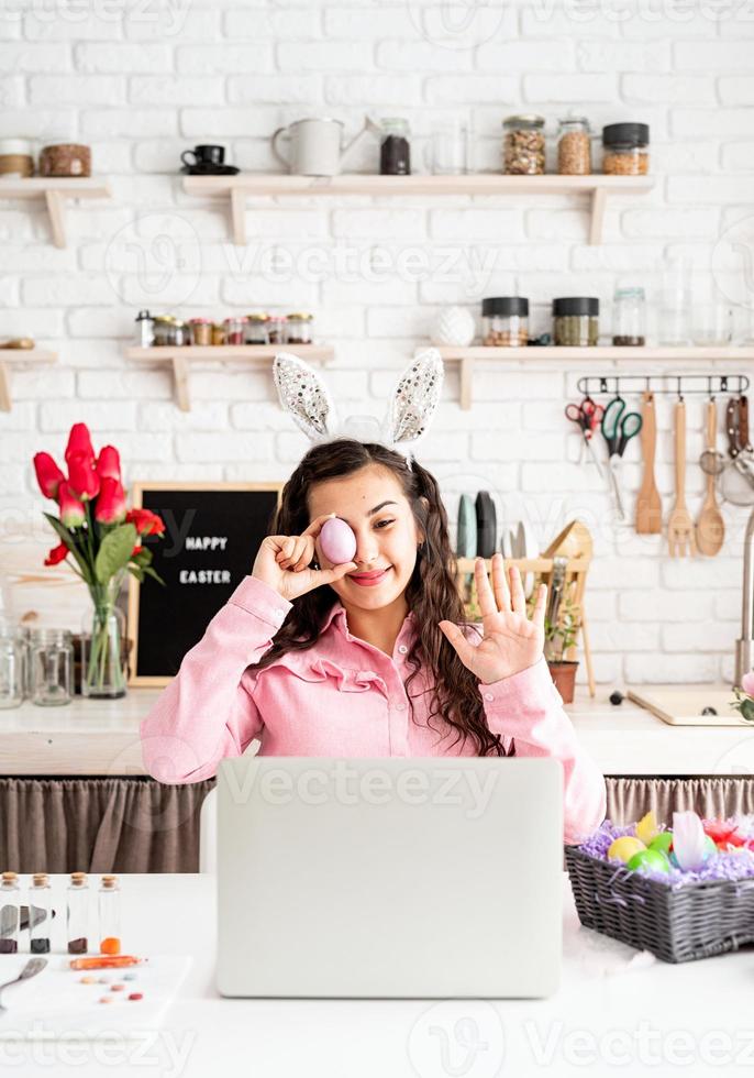 mulher cumprimentando seus amigos online, comemorando a páscoa foto