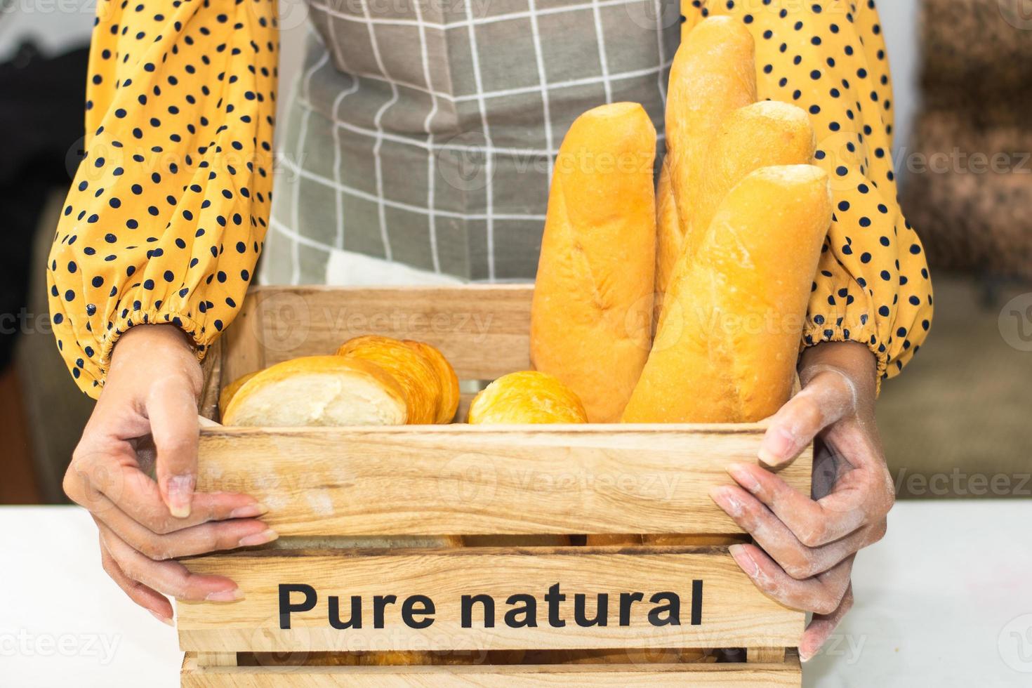 mão segurando um balde de pão fresco na padaria foto