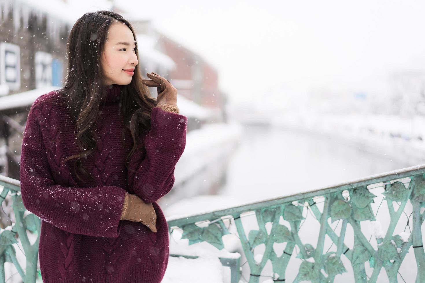 mulher asiática sorrindo feliz por viajar na neve, inverno foto