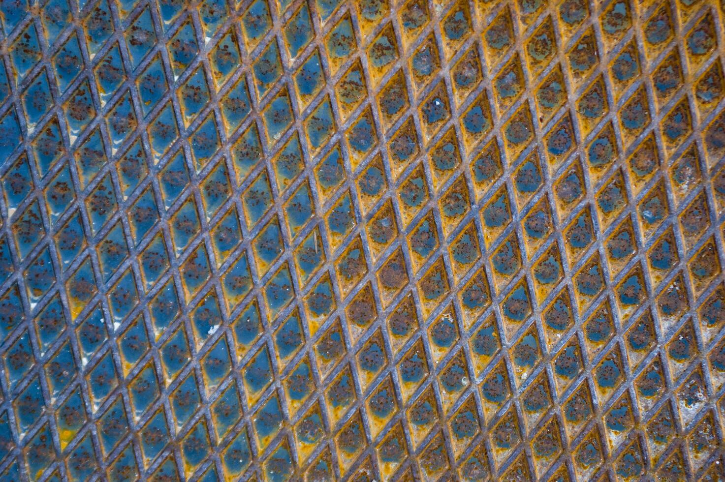 uma fechar acima do uma metal superfície com azul e amarelo cores foto