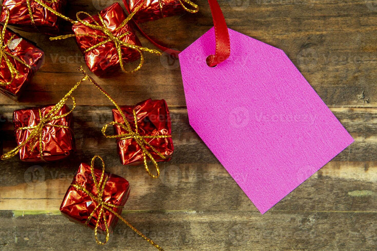 elementos decorativos de natal ao lado do cartão com fita vermelha e espaço para escrever foto