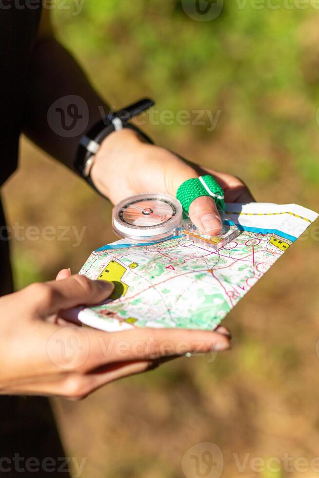 mulher segurando uma mapa e a bússola durante orientação competições. foto