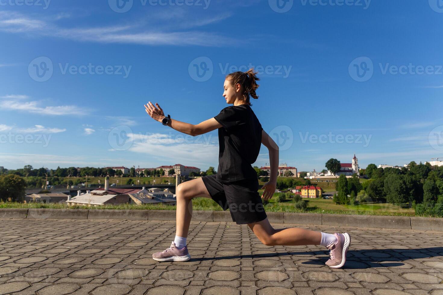 jovem, em forma e desportivo menina dentro Preto roupas alongamento depois de a exercite-se dentro a urbano cidade parque. foto