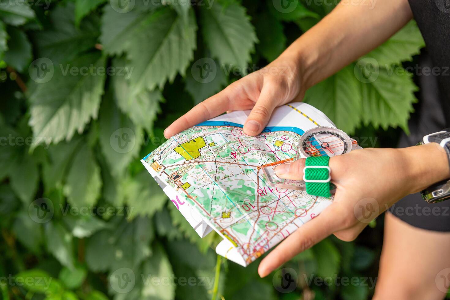 mulher segurando uma mapa e a bússola durante orientação competições. foto