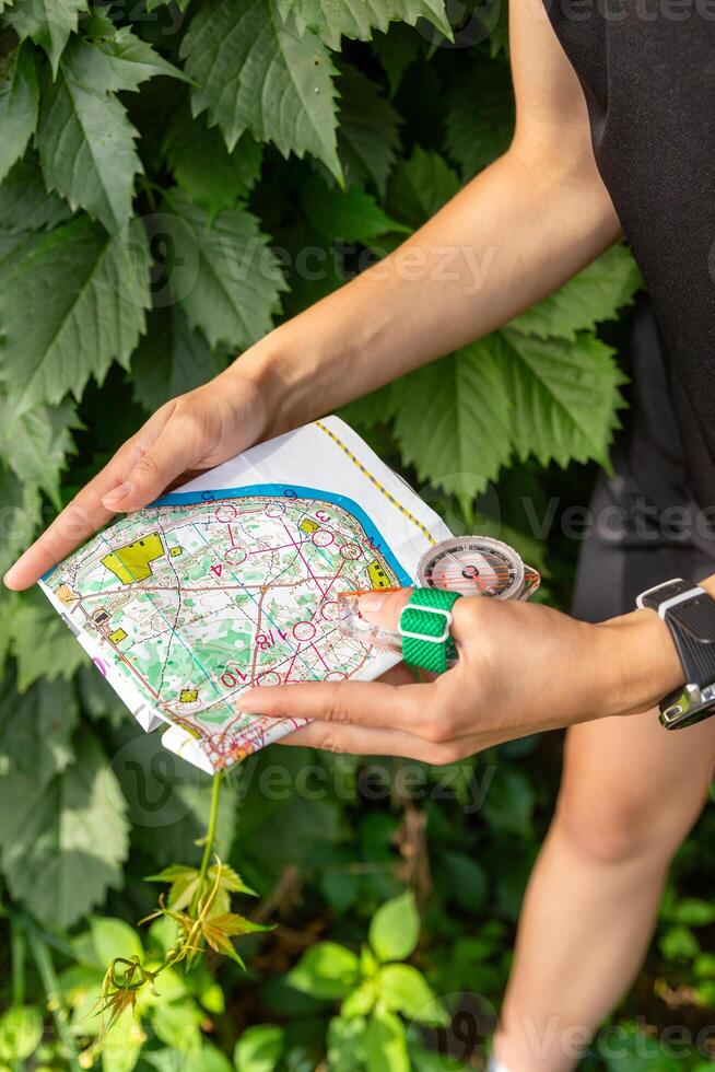 mulher segurando uma mapa e a bússola durante orientação competições. foto