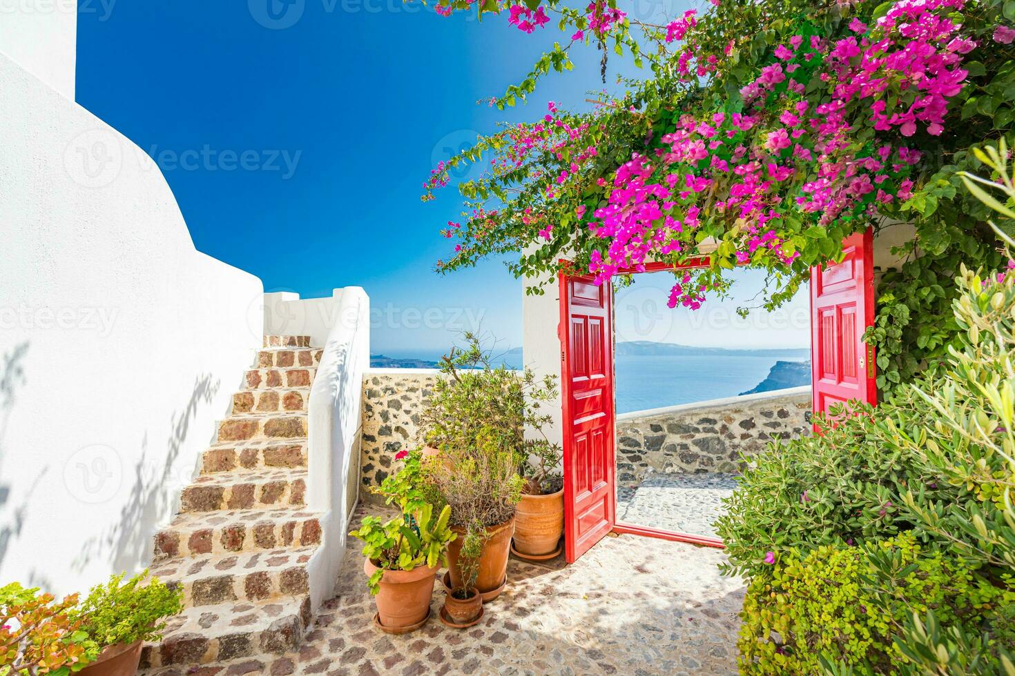 fundo de viagem fantástico, paisagem urbana de santorini. porta vermelha ou portão com escadas e arquitetura branca sob céu azul. conceito de férias de férias de verão idílico. maravilhosas vibrações de luxo de verão foto