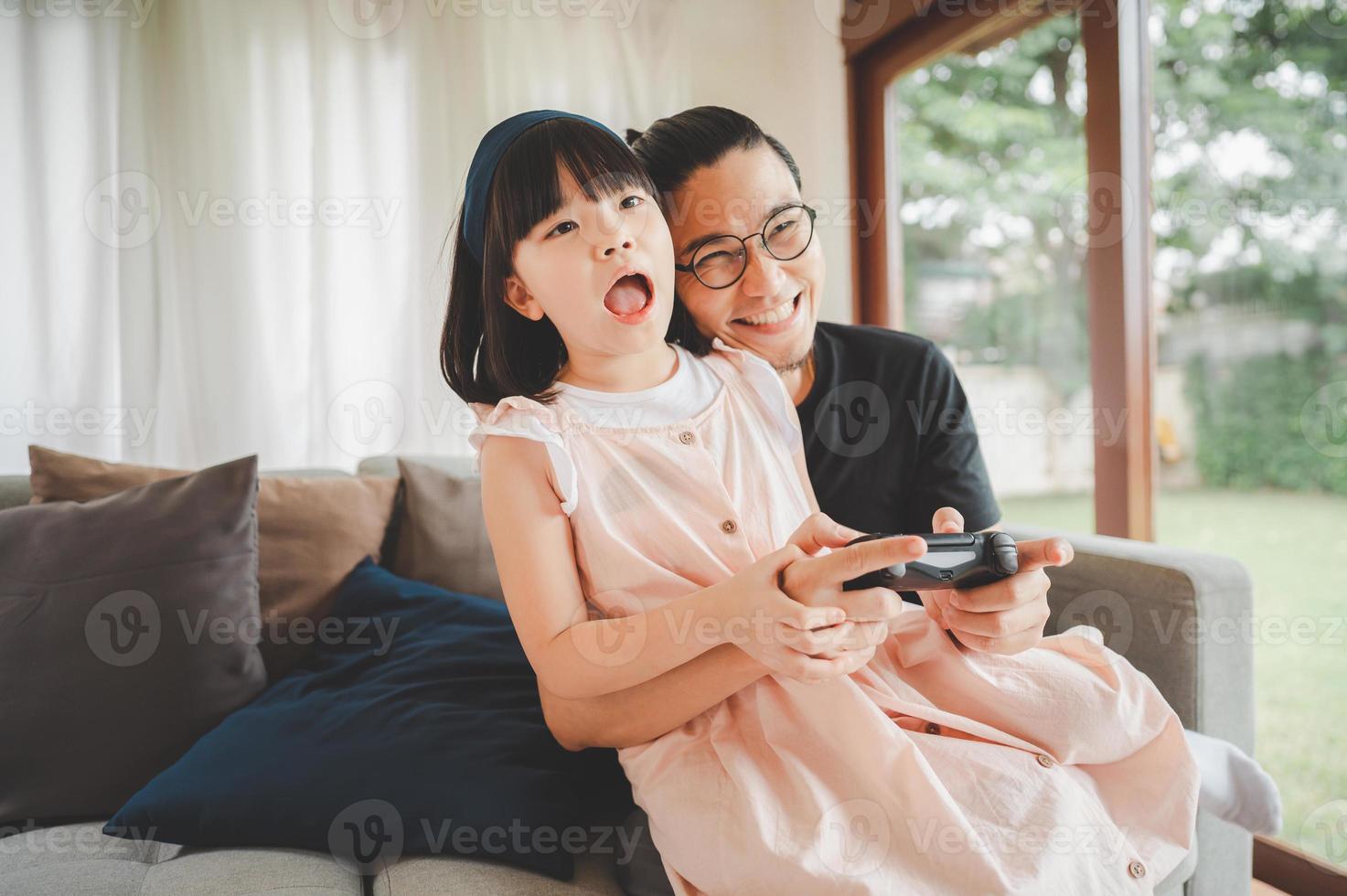 pai e filha asiáticos jogam videogame juntos foto