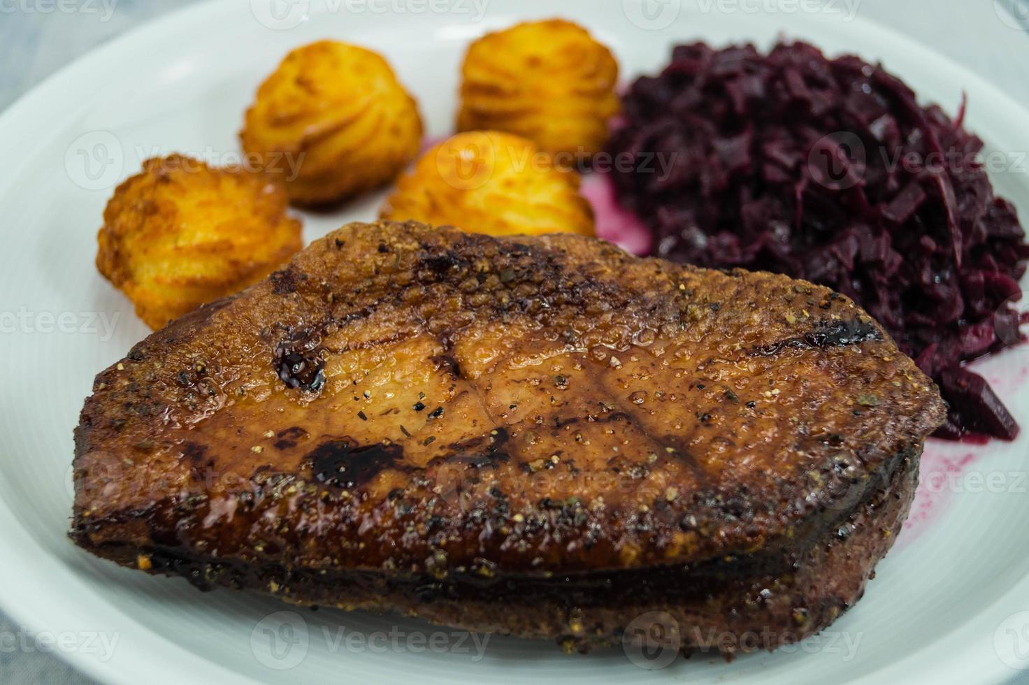 peito de pato frito com couve roxa e croquetes foto