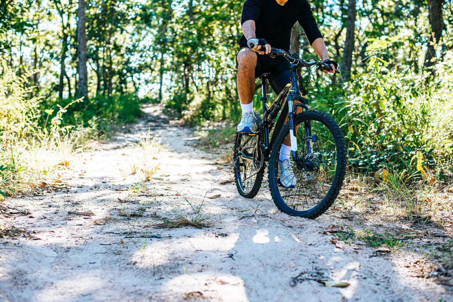 o homem andando de bicicleta em um caminho de montanha foto