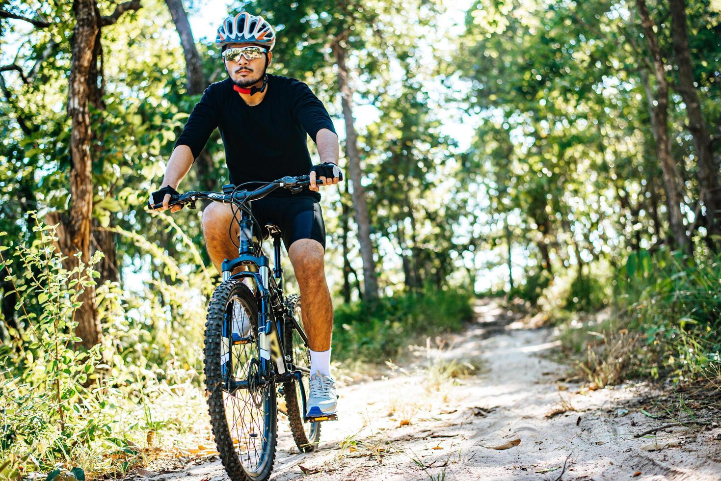 o homem andando de bicicleta em um caminho de montanha foto