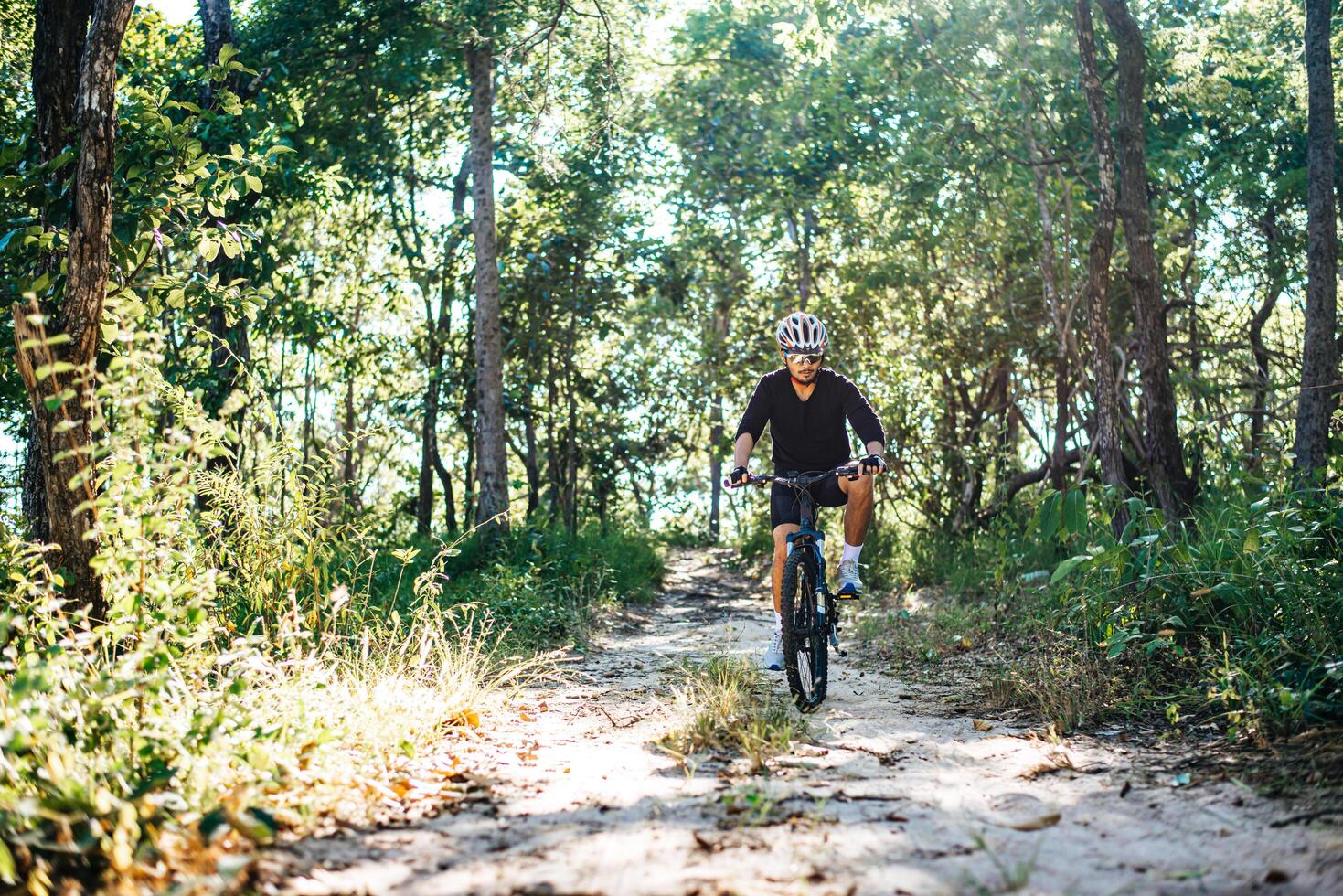 o homem andando de bicicleta em um caminho de montanha foto