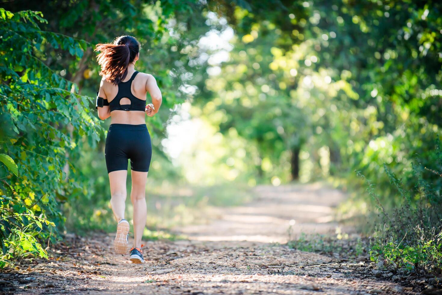 mulher jovem aptidão correndo em uma estrada rural. mulher esporte correndo. foto