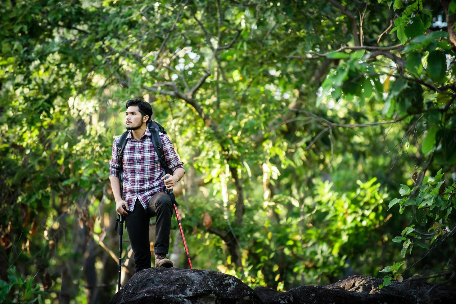 jovem caminhante relaxando no topo de uma montanha, aproveite a natureza e a aventura. foto