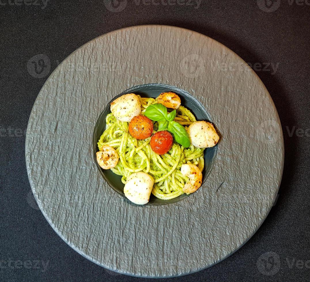 conchas de água salgada fritas no espaguete com pesto verde foto