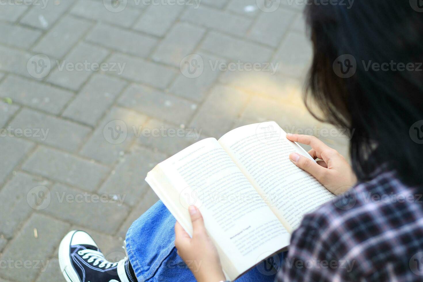 feliz atento jovem ásia mulher Faculdade aluna lendo uma livro dentro a parque, Educação conceito foto