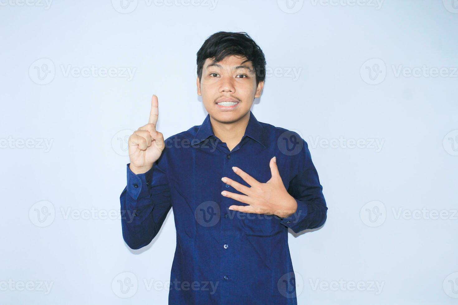 grato ásia homem de negocios é sorridente depois de sofrimento a partir de coração ataque mostrar apresentando gesto com apontando dedo acima foto