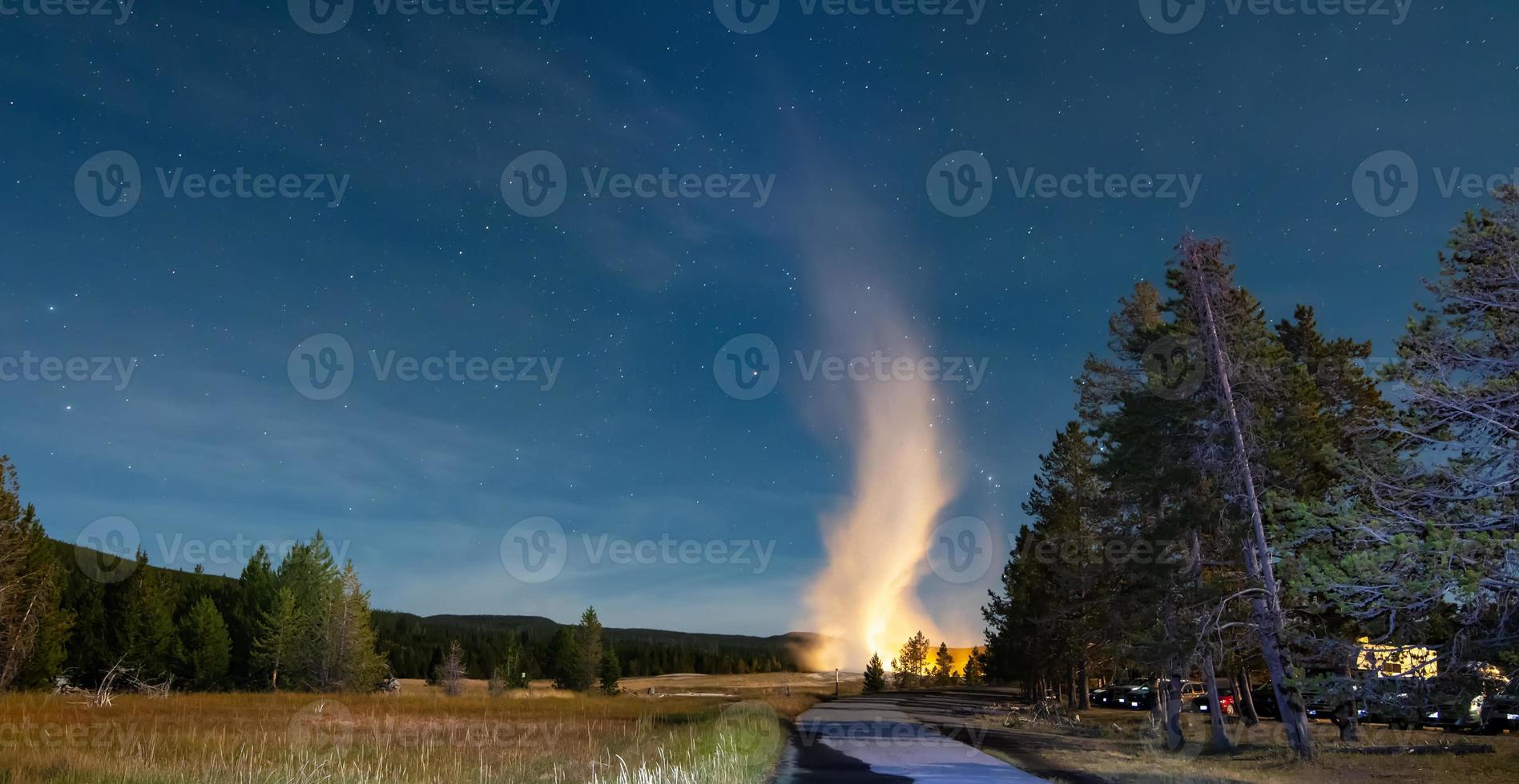 erupção do velho e fiel gêiser no parque nacional de yellowstone à noite foto