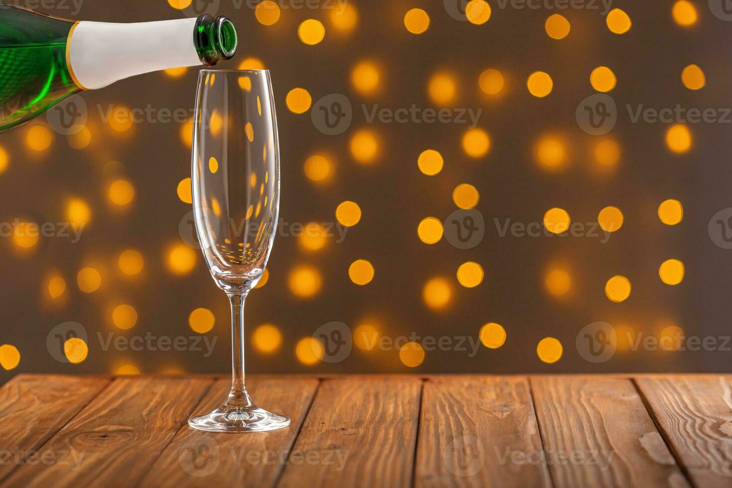 óculos com champanhe em uma de madeira fundo contra uma bokeh fundo do luzes foto
