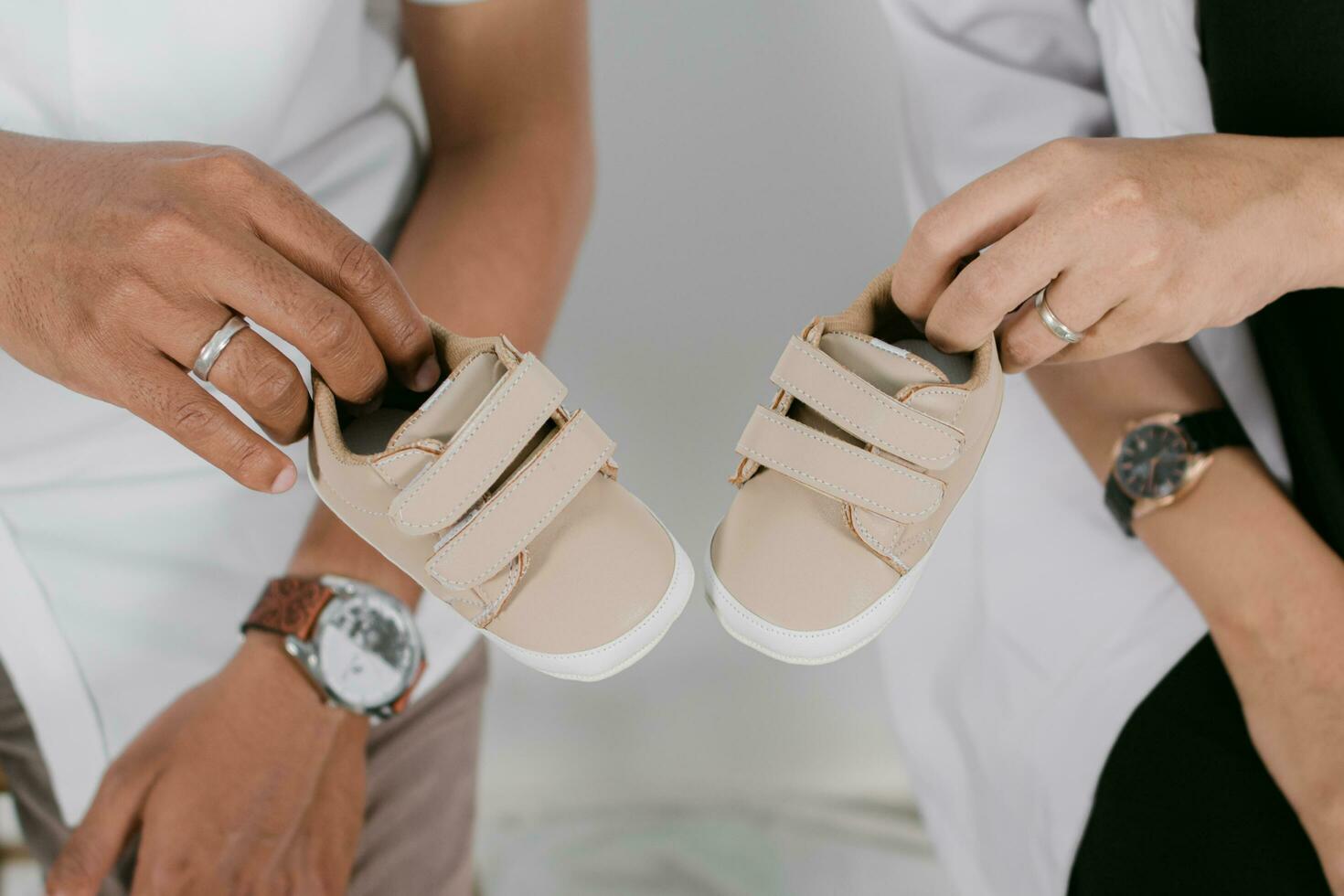 uma homem e mulher estão segurando seus Bêbês sapatos foto