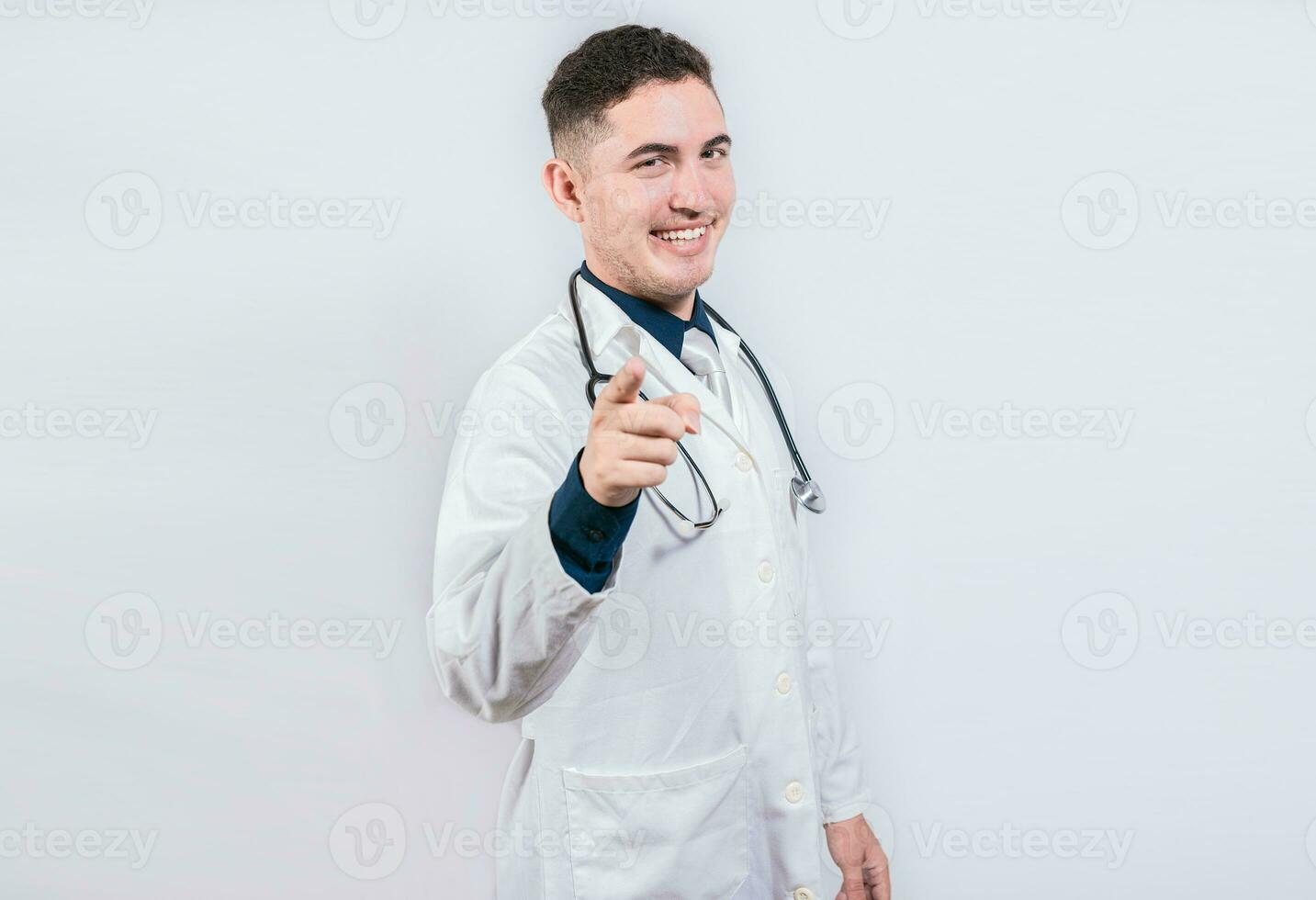 bonito médico apontando às a Câmera. amigáveis e sorridente médico apontando às você, jovem médico apontando às você foto