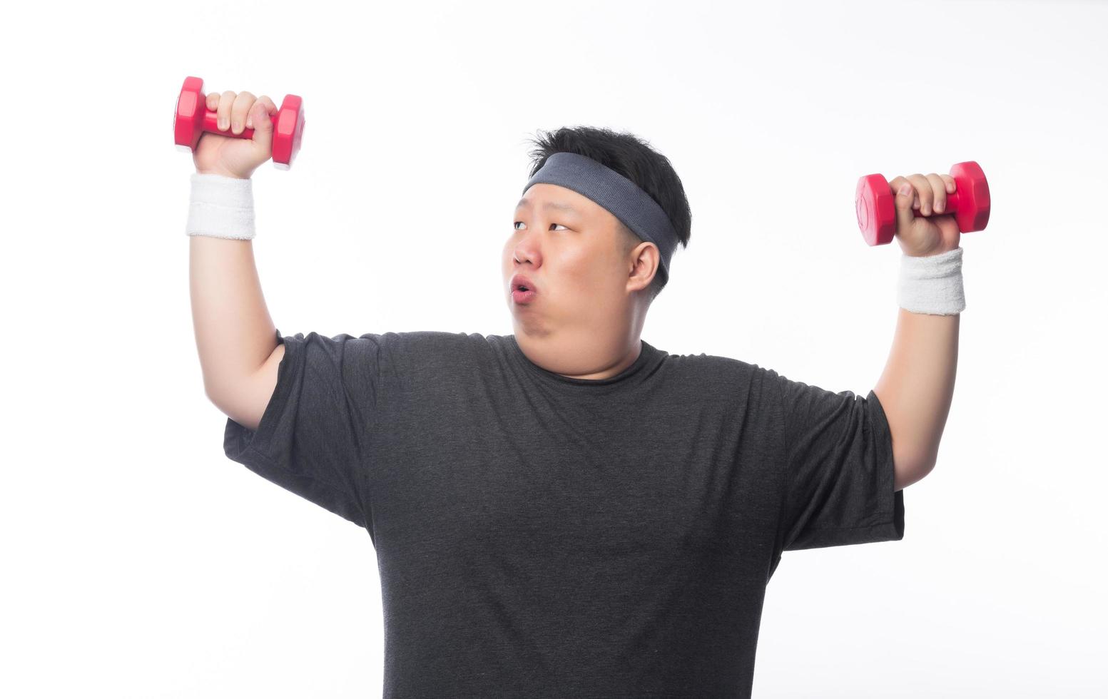 jovem gordo exercitando-se com halteres foto