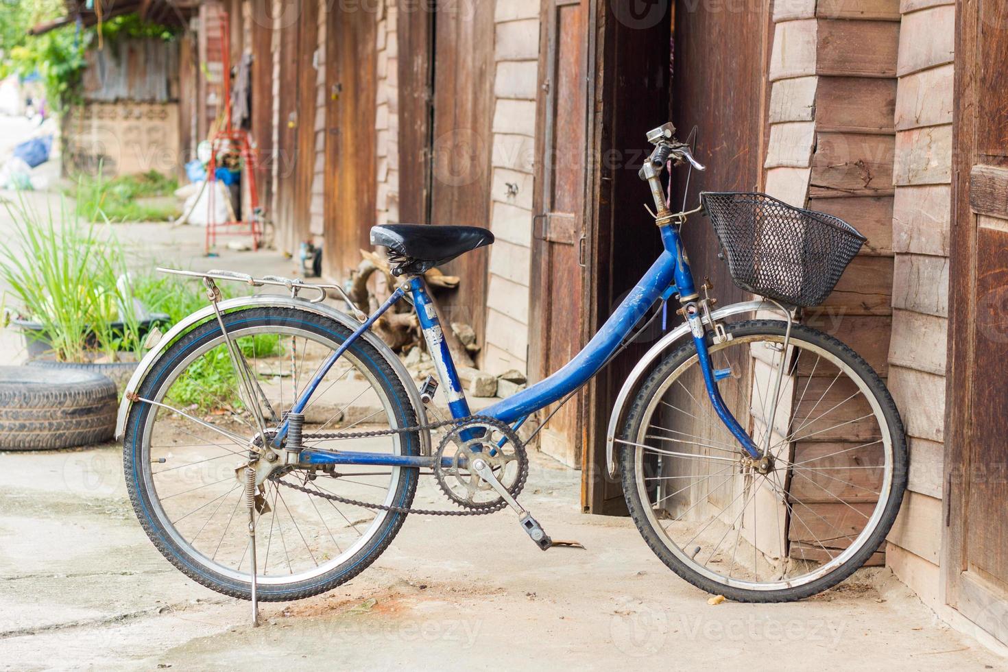 bicicleta velha em frente a parede de madeira em casa foto