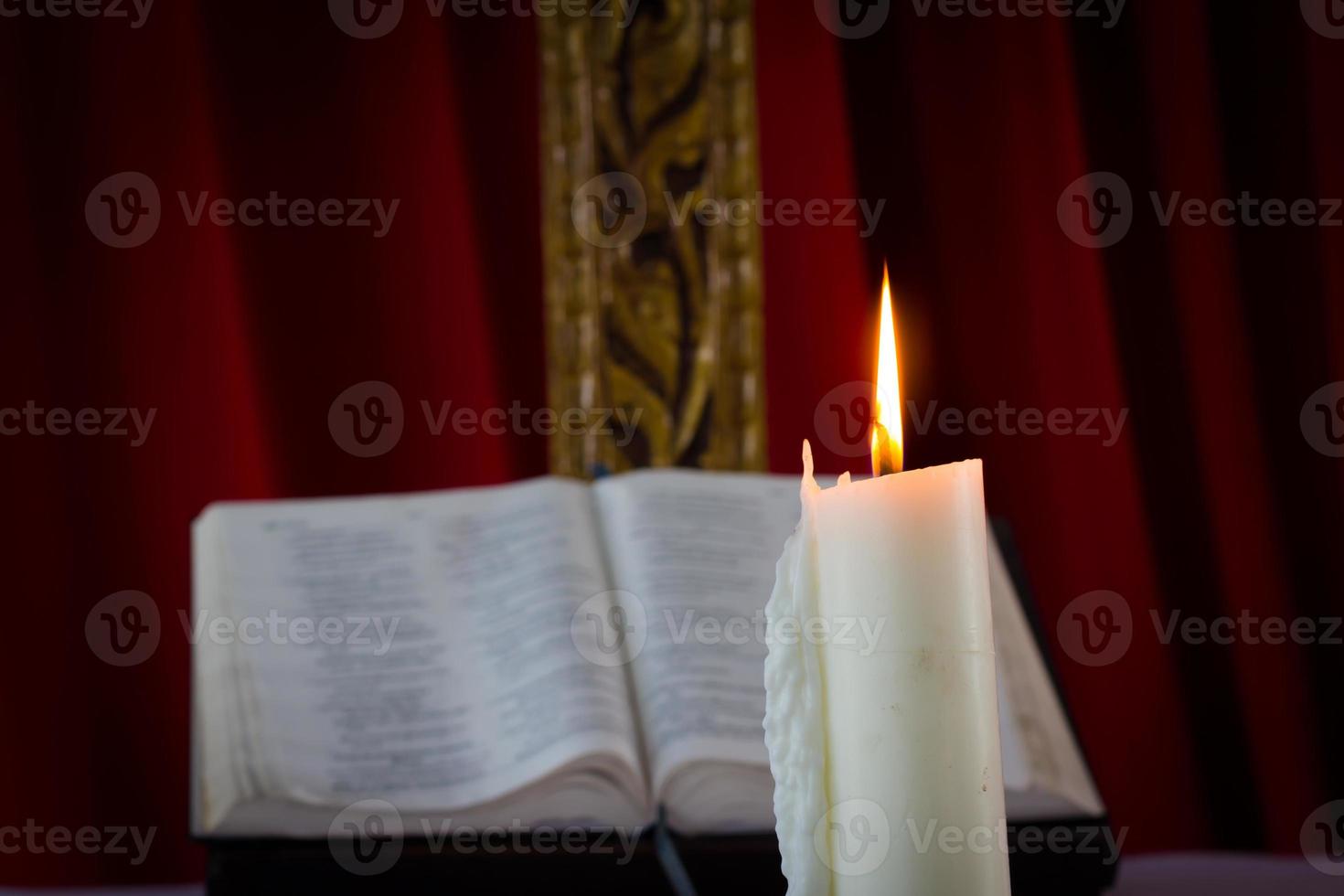 Bíblia com velas ao fundo. cena com pouca luz. foto