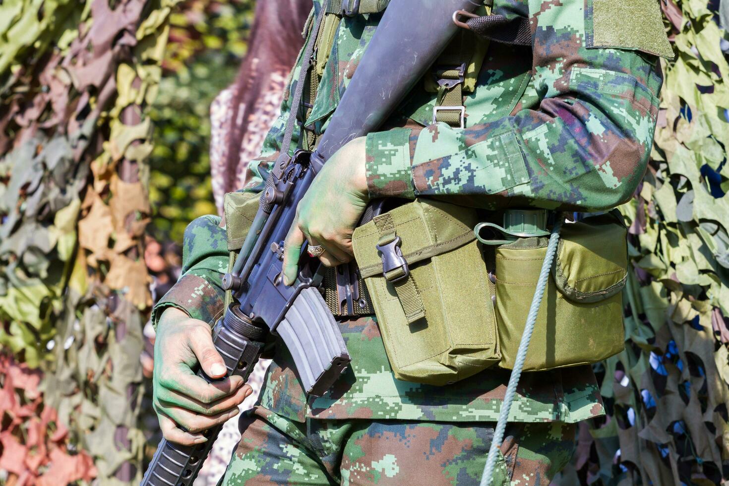 closeup homem soldado mãos segurando uma metralhadora foto