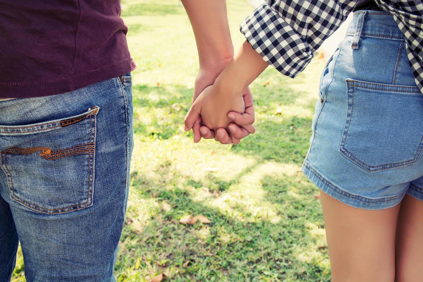 jovem casal apaixonado andando no parque de mãos dadas. foto