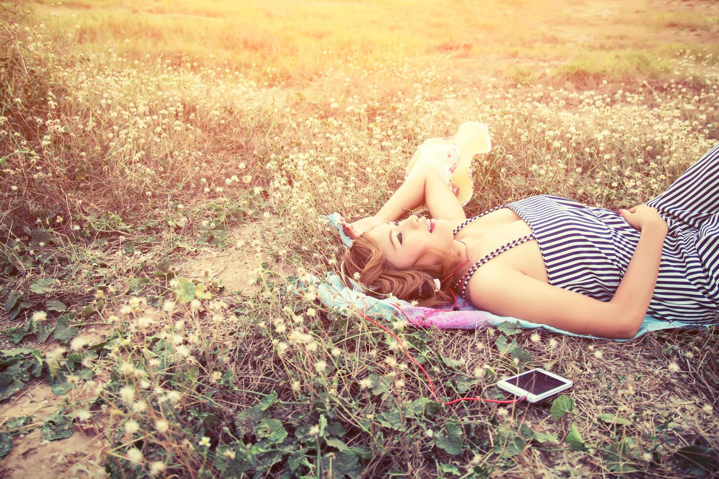 mulher ouvindo música de smartphone no campo de flores divirta-se. foto