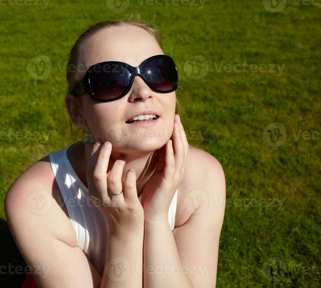 jovem mulher dentro oculos de sol é banho de sol. foto