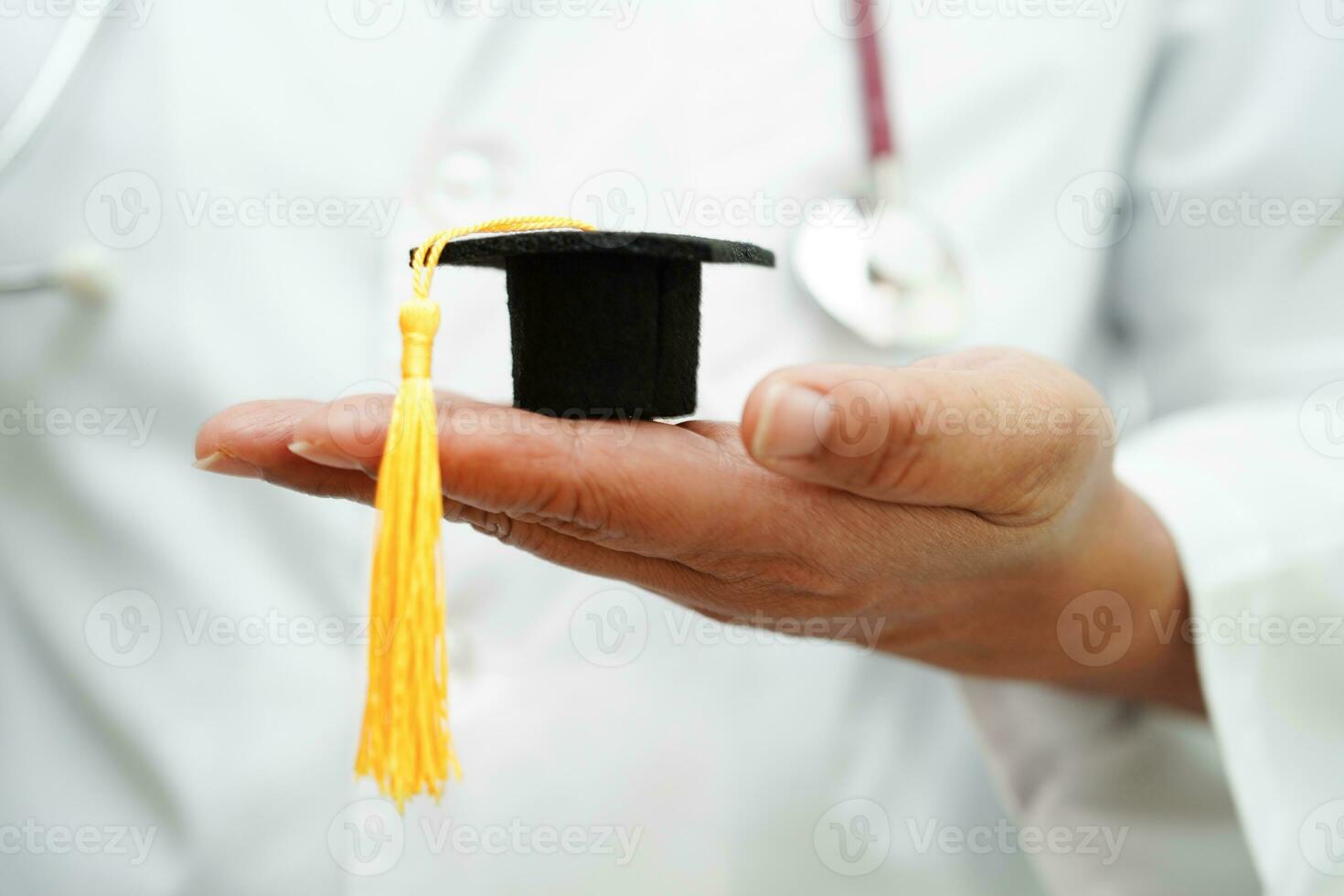 médico de mulher asiática segurando o chapéu de formatura no hospital, conceito de educação médica. foto