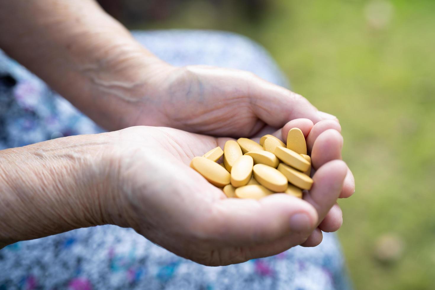 mulher idosa idosa sênior asiática segurando a droga de comprimidos de vitamina c na mão, conceito médico forte e saudável. foto