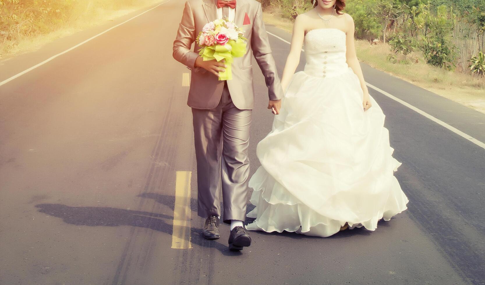 noivo e noiva caminhando na estrada vão se casar foto