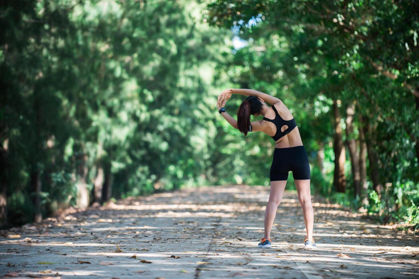 mulher jovem aptidão esticando as pernas antes de correr. foto