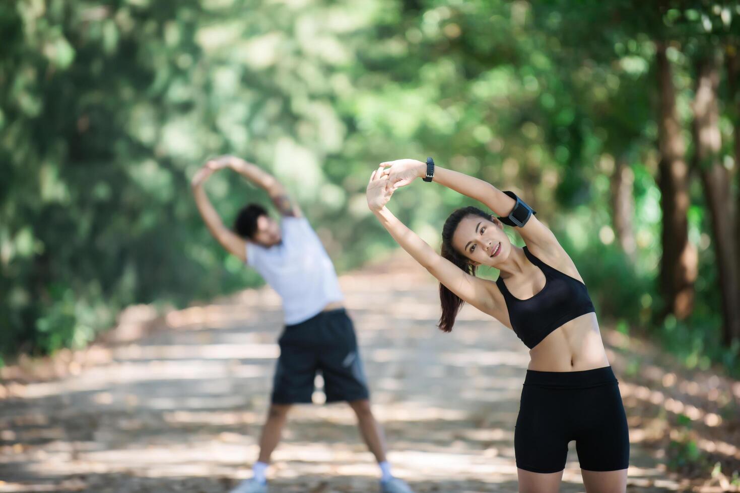 homem e mulher alongando-se juntos no parque. foto