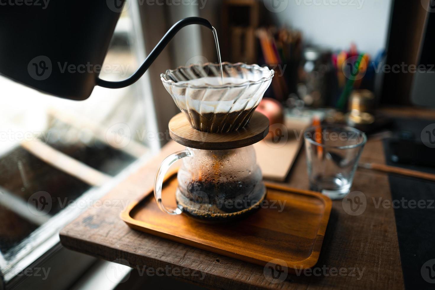 gotejar café em casa, derramar água quente sobre um gotejamento de café foto