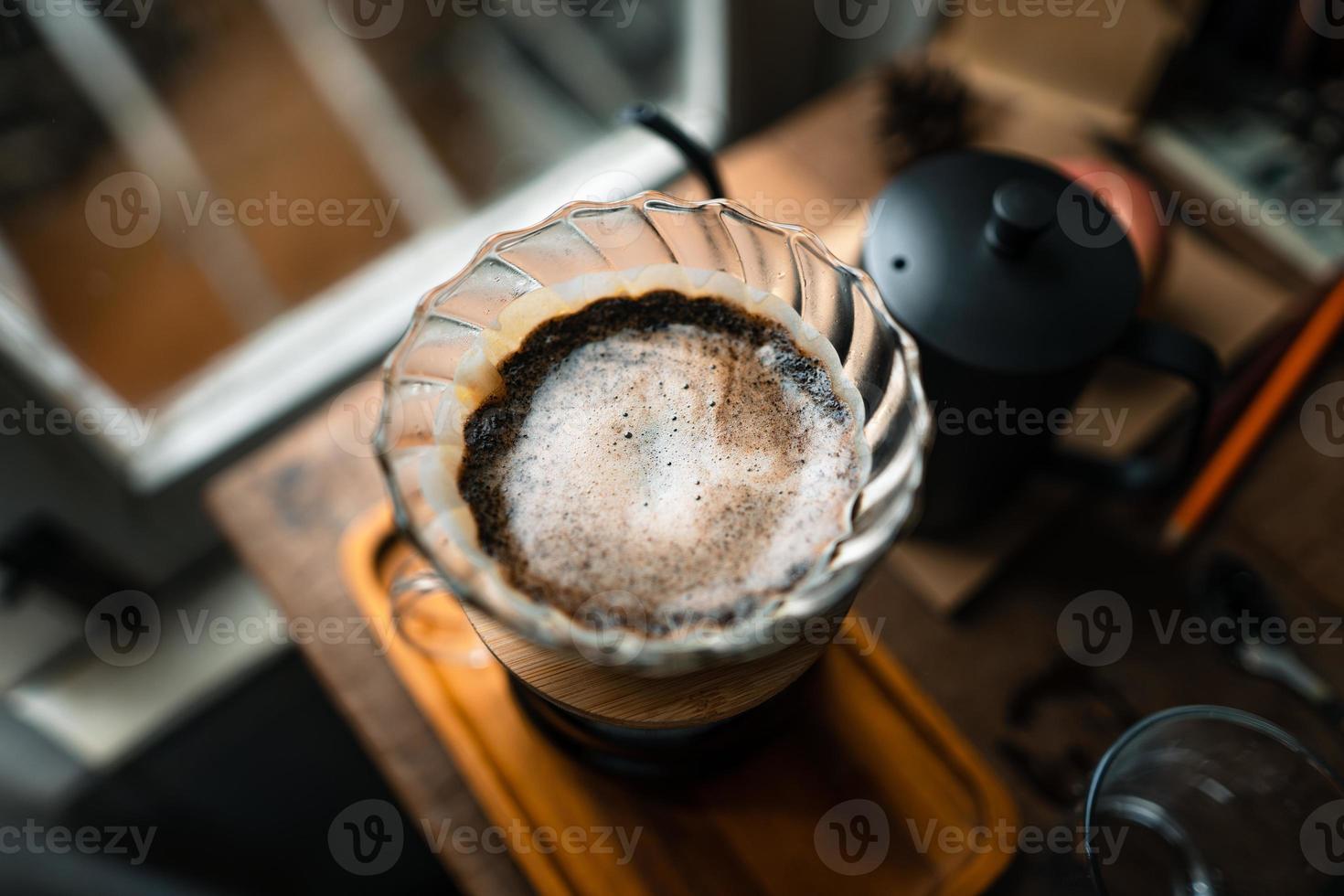 gotejar café em casa, derramar água quente sobre um gotejamento de café foto