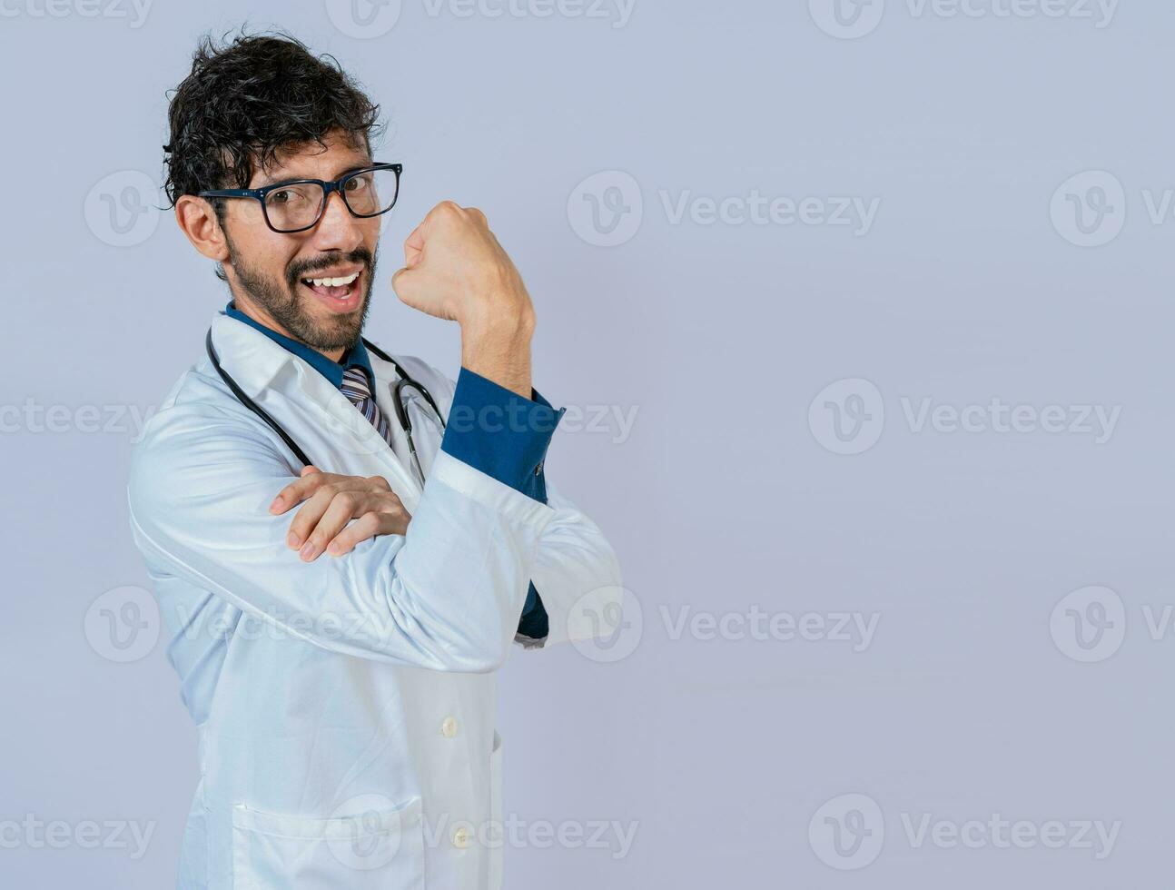 médico mostrando músculo. jovem médico mostrando força com dele braço foto