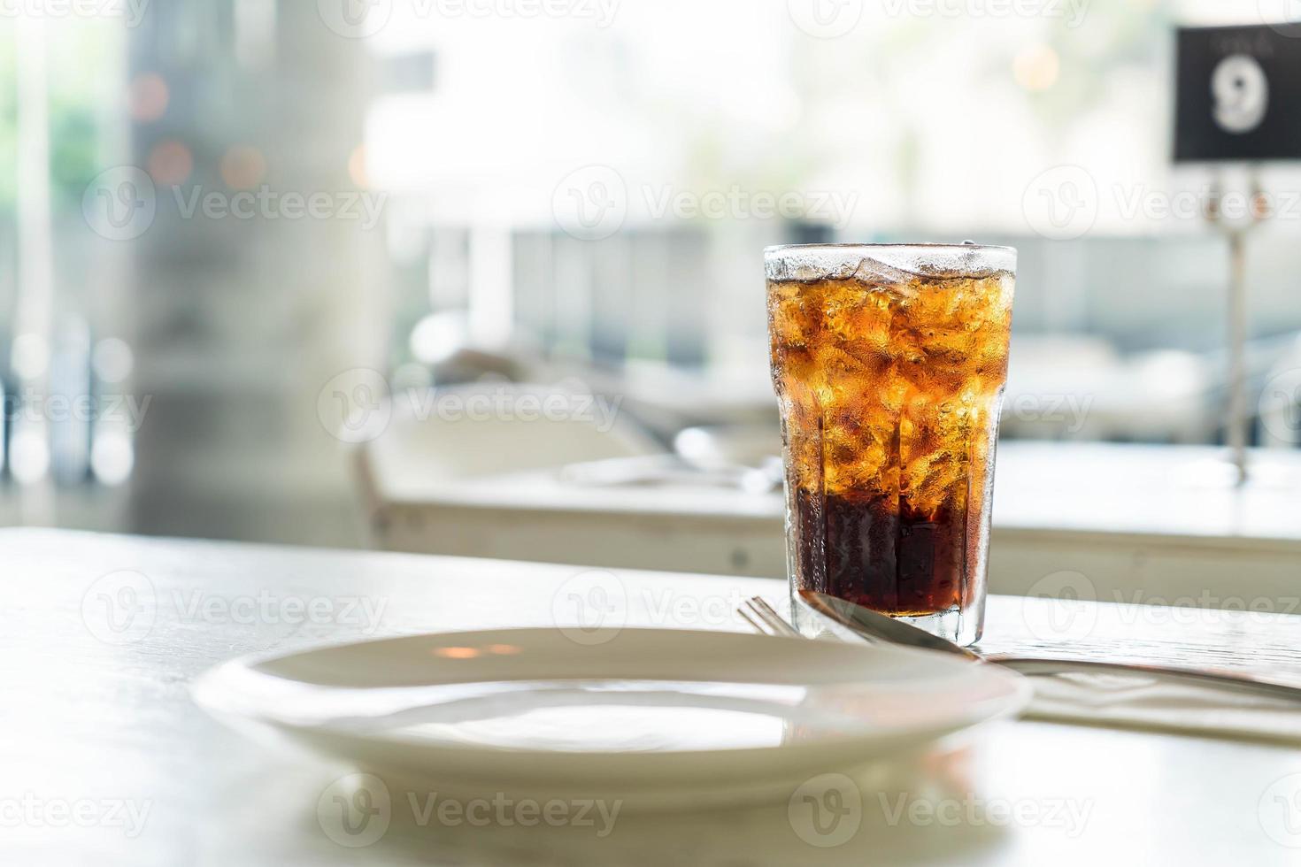 copo de cola gelado na mesa foto