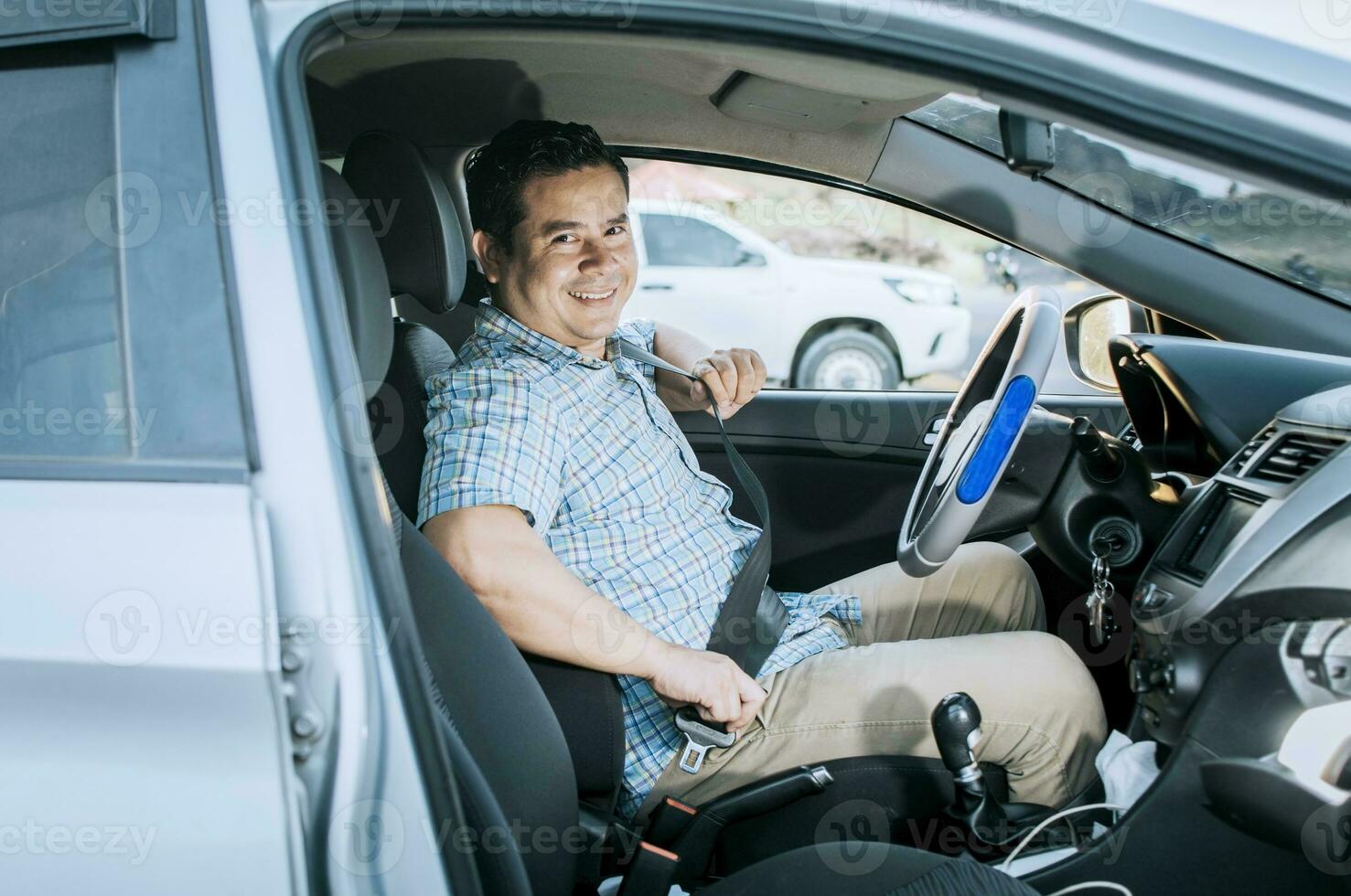 sorridente masculino motorista colocando em dele assento cinto. conceito do uma motorista dentro dele carro colocando em dele assento cinto. sorridente pessoa colocando em assento cinto, feliz motorista colocando em dele assento cinto foto